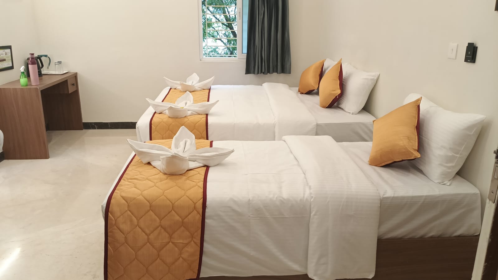 Double bed room with two beds, white linens, and orange runners